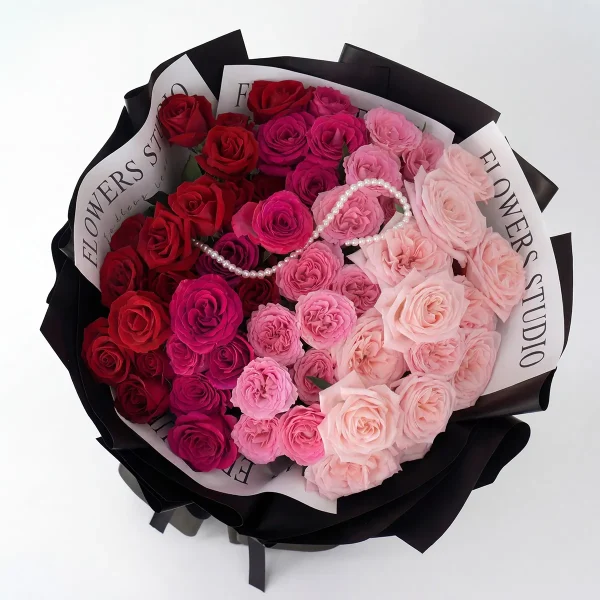52 gradient roses top view overhead Overhead view of 52 roses in a perfect red to pink gradient transition, featuring the signature pearl necklace detail.