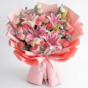 Top-down view of the pink lily and carnation arrangement, showcasing the abundance of fresh blooms and professional floral design.