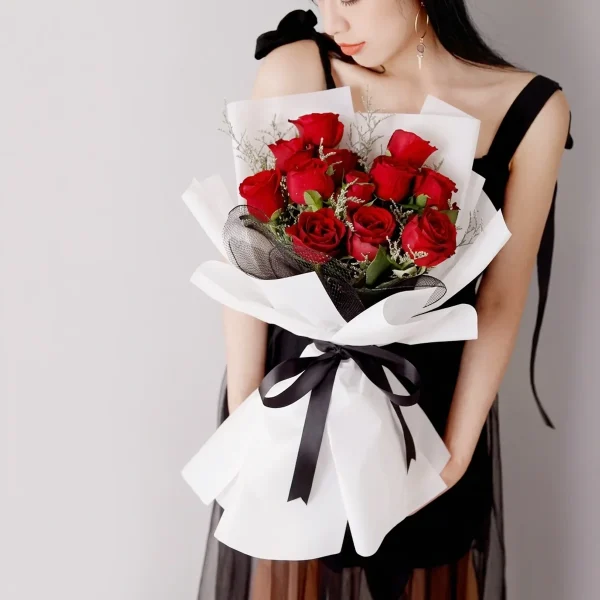 red roses bouquet model presentation china A model holding a stylish bouquet of 11 red roses, showcasing the grand size and elegant black and white gift presentation.