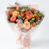 An elegant garden-style bouquet featuring peach roses, vibrant tulips, and purple accents in soft pink wrapping. Luxury flower delivery in China.