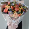 Real-life photo of a florist holding the massive Sunset Glow mixed bouquet of peach roses, vibrant tulips, and purple accents. Demonstrates the actual size and lush texture for China flower delivery.